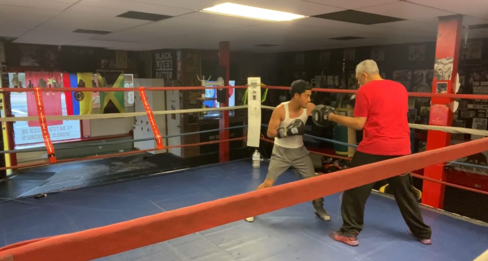 Coach Jamal Valdez-Allen holding mitts for a boxer during a private boxing lesson at Lightning Boxing Club in Oakland